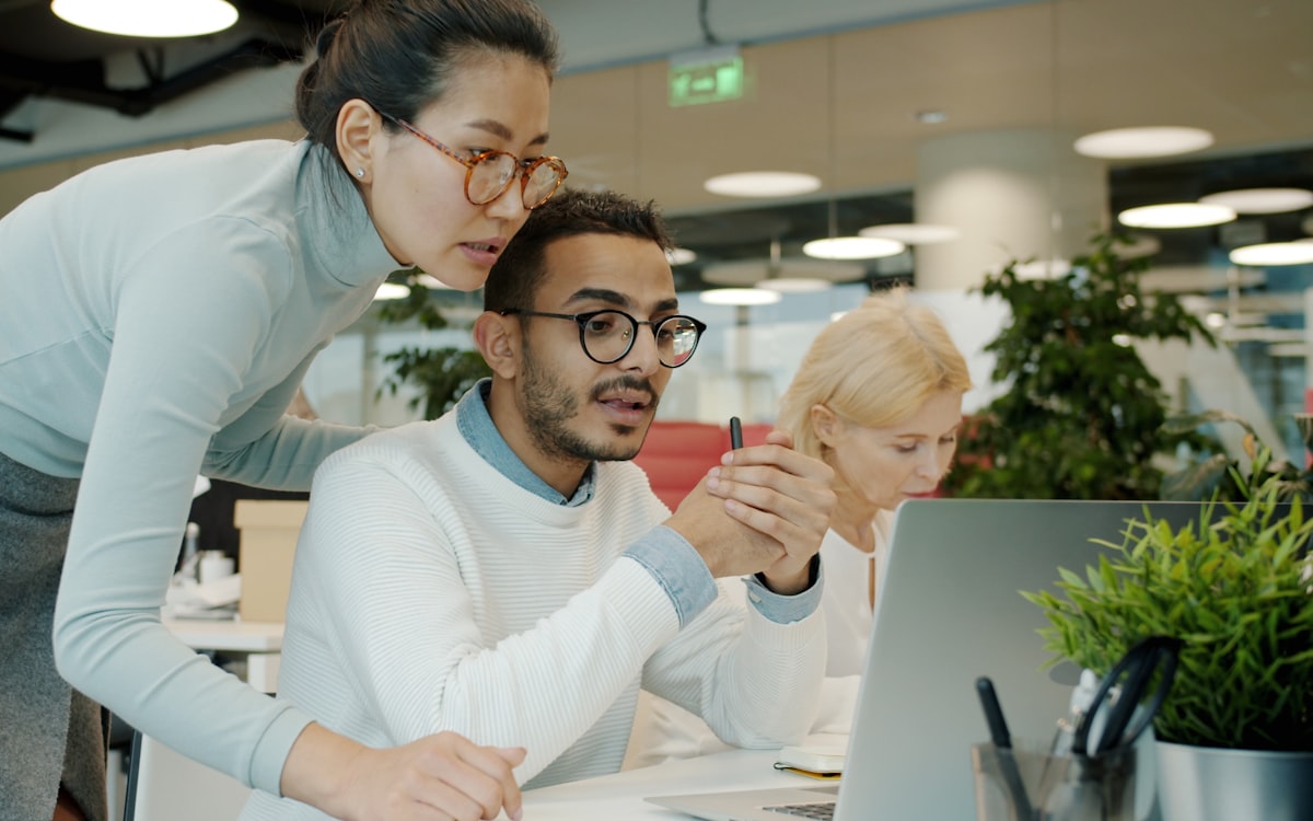 Two colleagues working through a task at one laptop