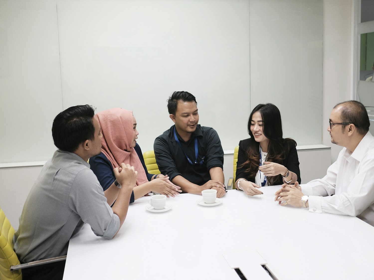 Five colleagues at a meeting table